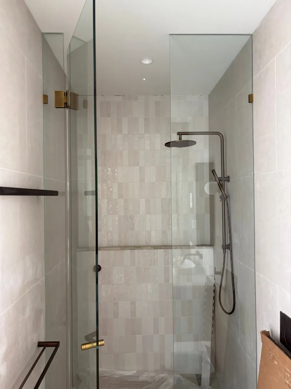 Tiled walk-in shower lit from above