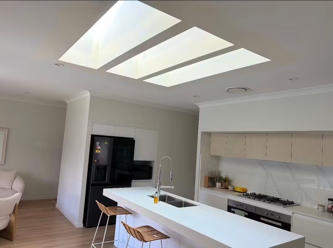 Three skylights above a modern kitchen