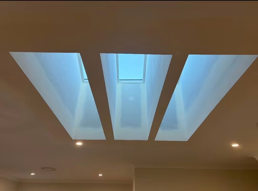 Three skylights glowing in a modern ceiling