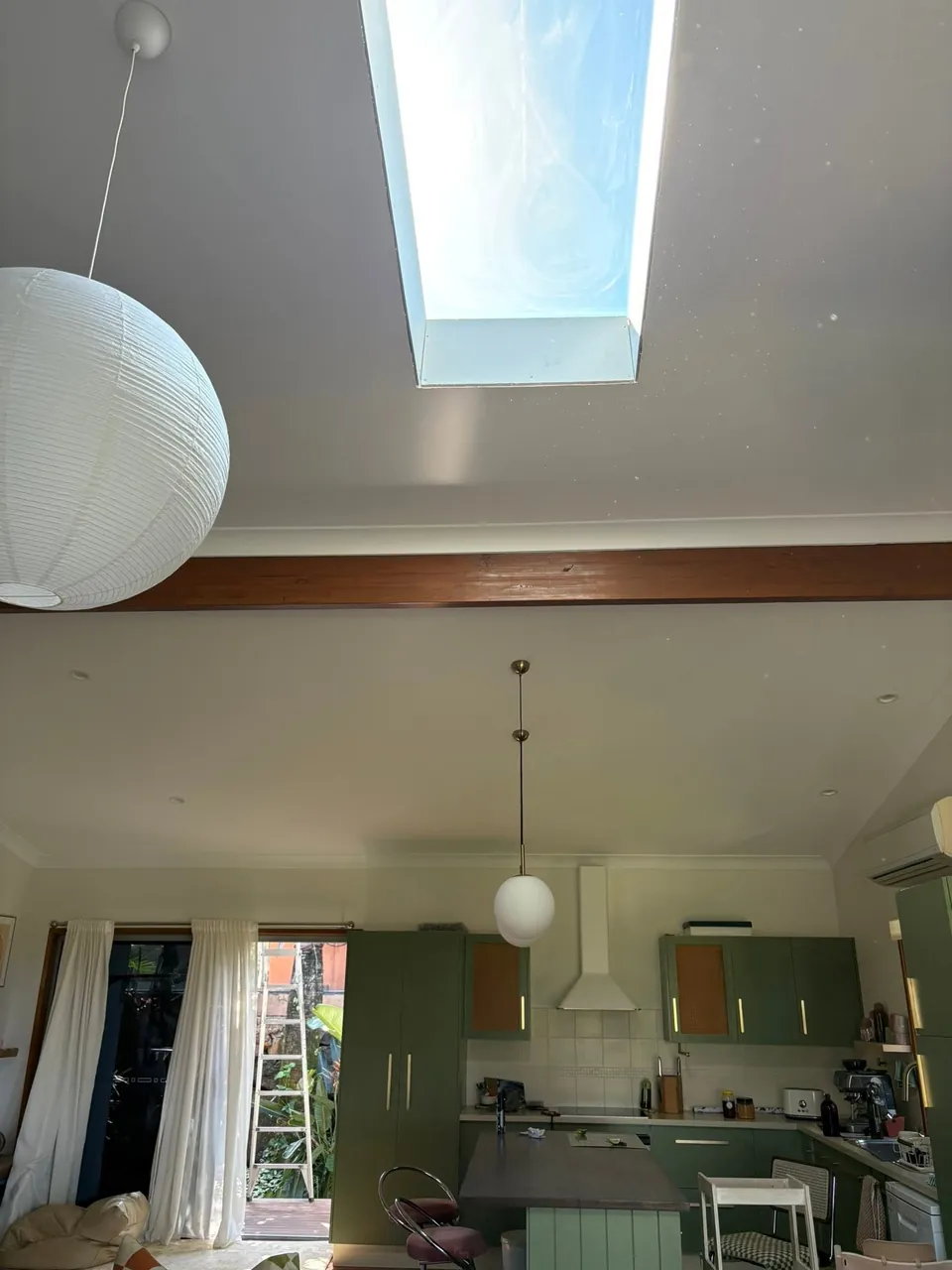 Long skylight shaft above a kitchen with a paper lantern