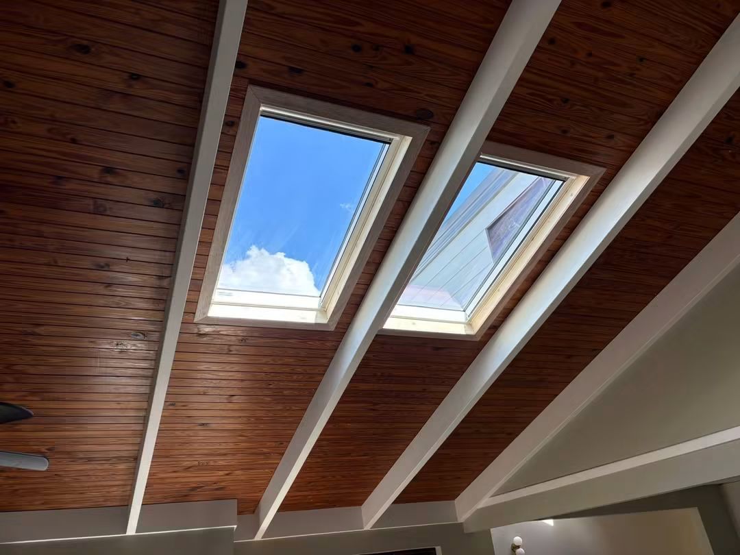 Two skylights in a white and timber raked ceiling