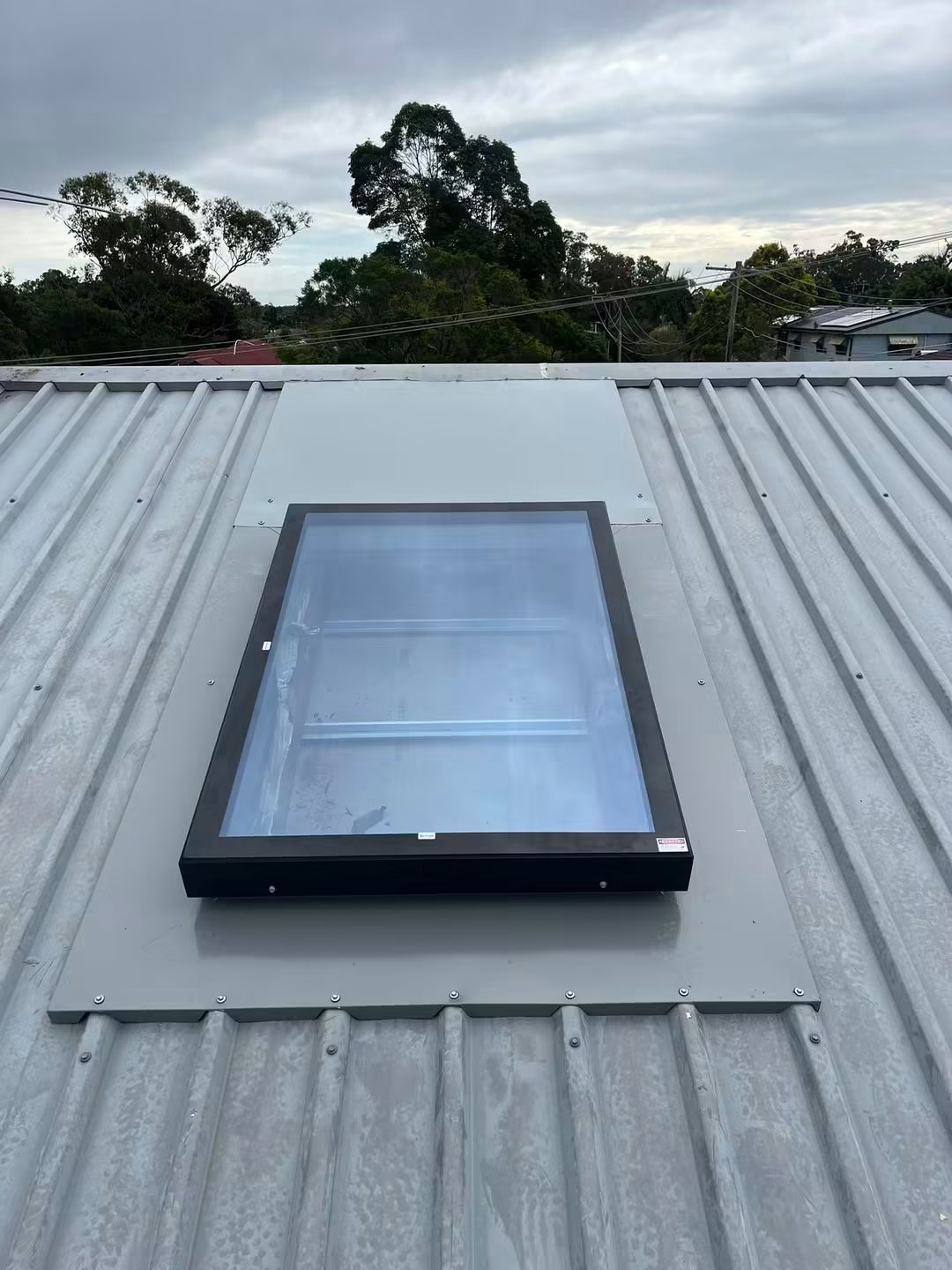 Skylight flashed into a low pitch metal roof