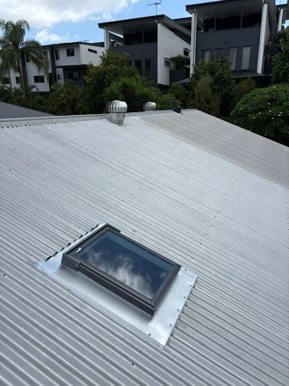Roof window flashed into a corrugated metal roof