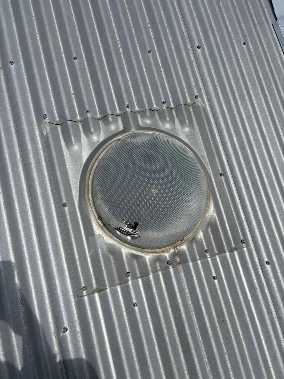 Tubular skylight dome on a corrugated metal roof