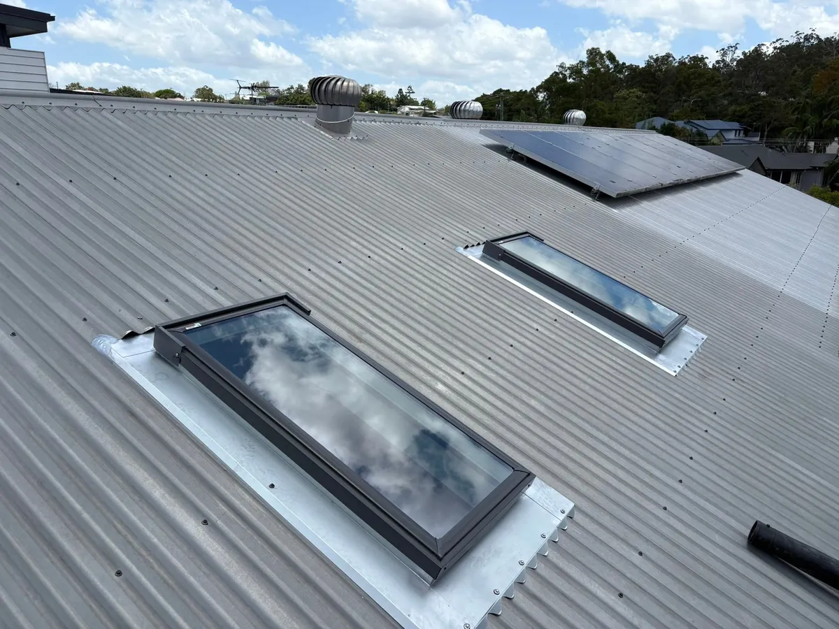 Two roof windows on a corrugated metal roof