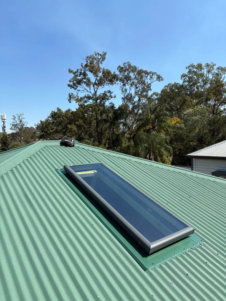 Roof window flashed into a green corrugated metal roof