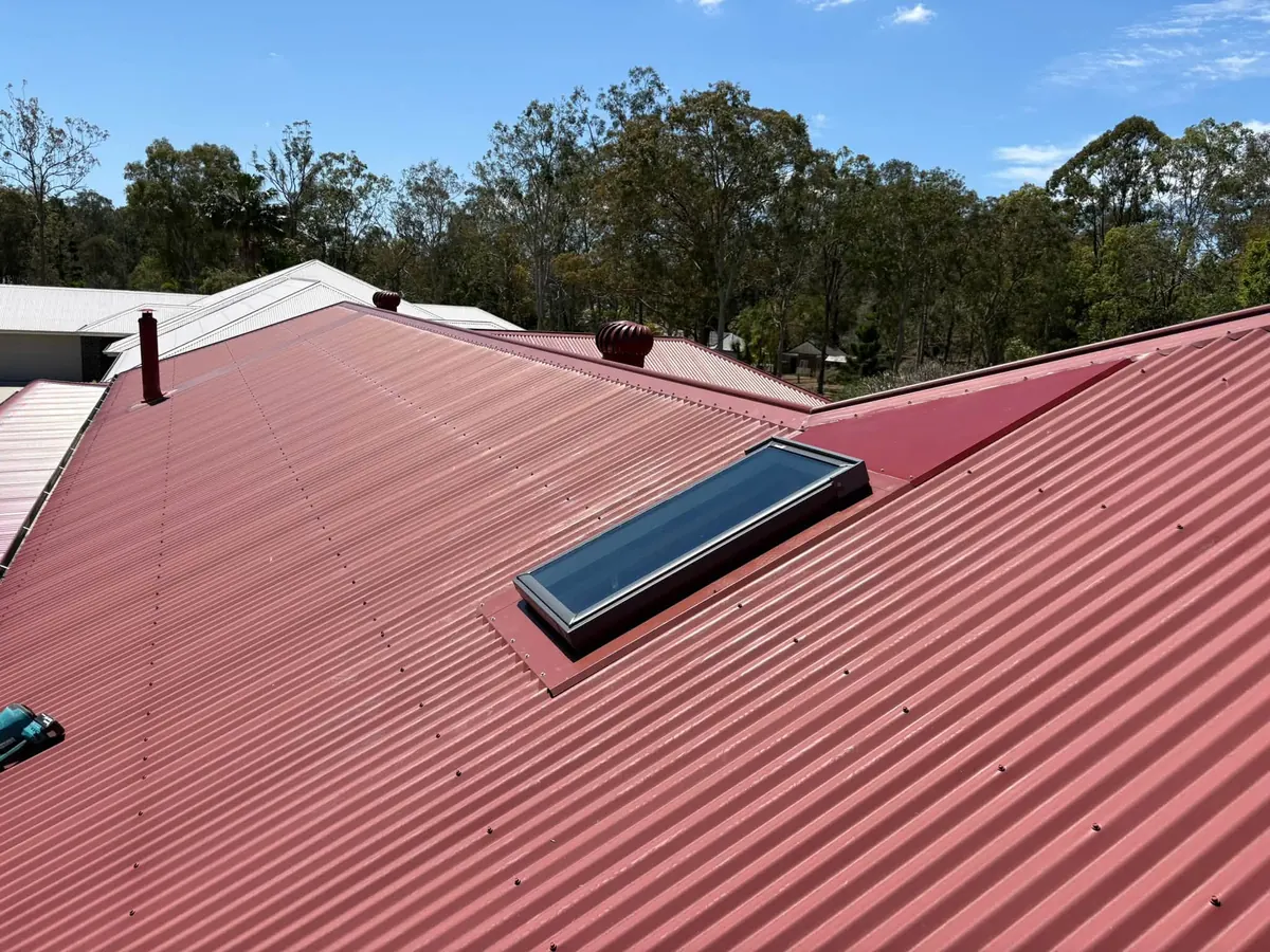 Roof window on a red corrugated metal roof